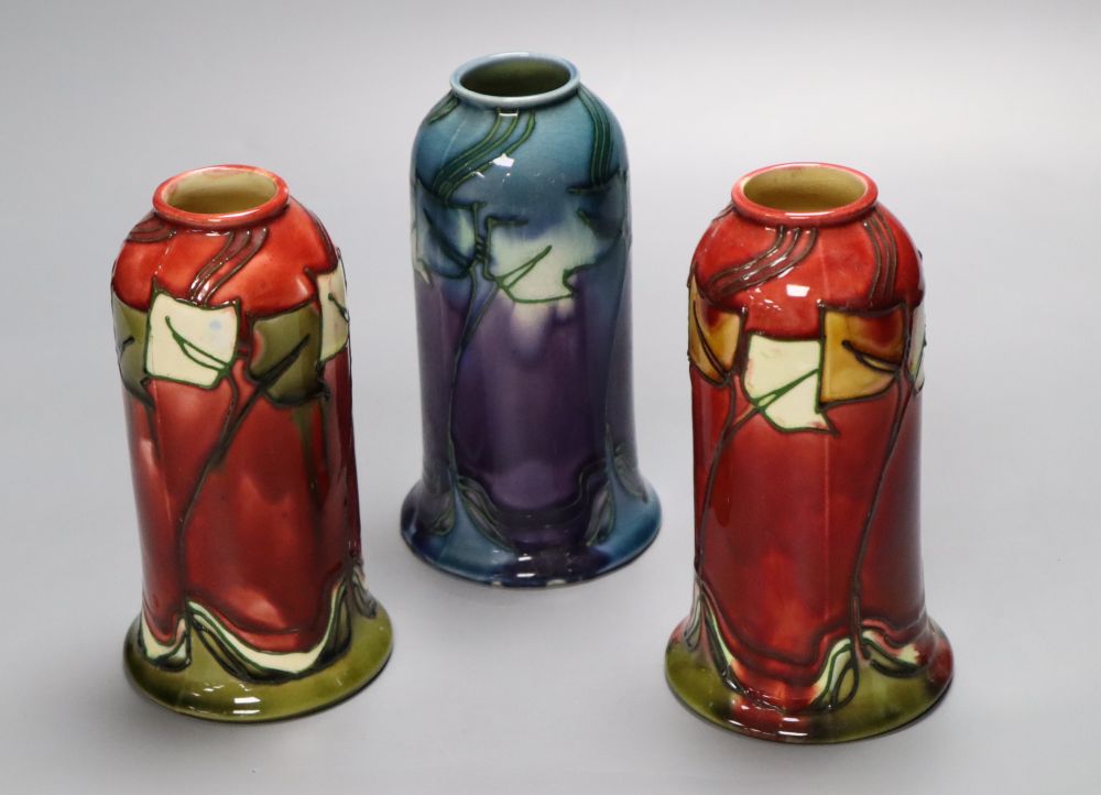 A pair of Minton Secessionist bell-shaped red ground vases (No 46) and a similar mauve-ground vase,